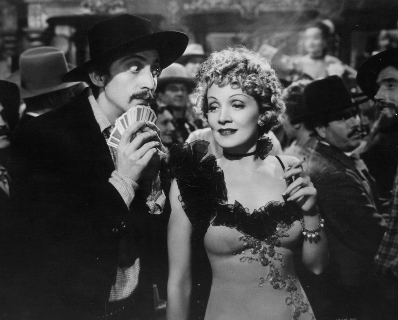 Marlene Dietrich Being Looked At By Man Holding Cards In A Scene From The Film 'Destry Rides Again', 1939.