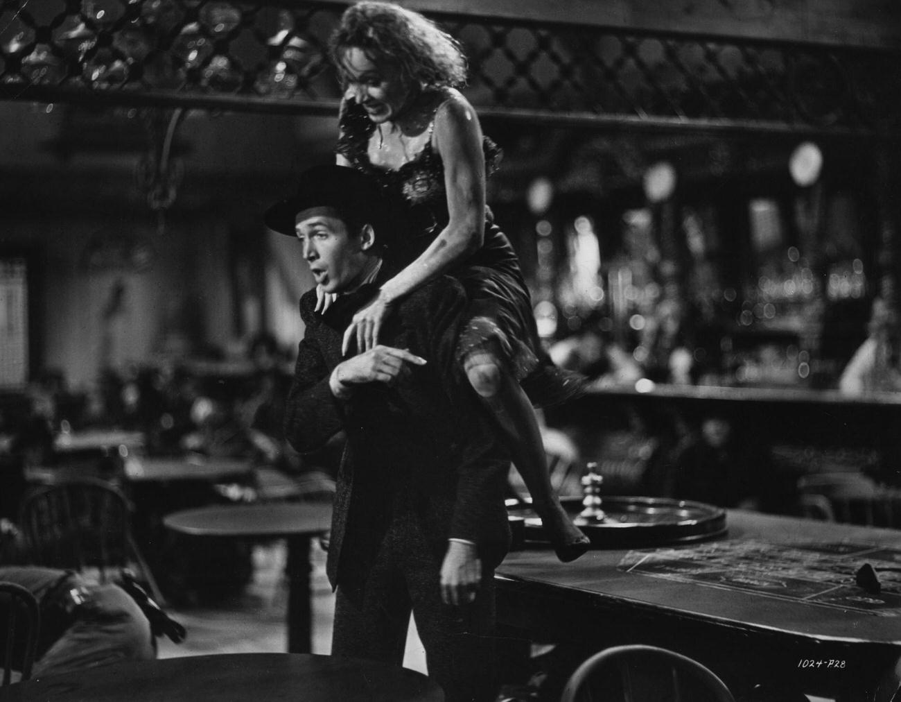 Marlene Dietrich Leaps Onto The Back Of James Stewart In A Scene From The Classic Western 'Destry Rides Again'.