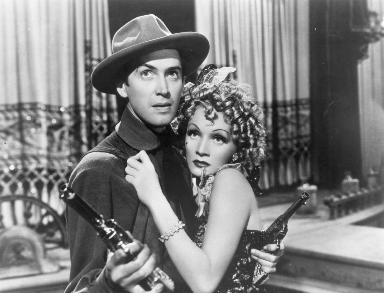 James Stewart Wields Two Pistols As German-Born Actor And Singer Marlene Dietrich Clings To Him Fearfully