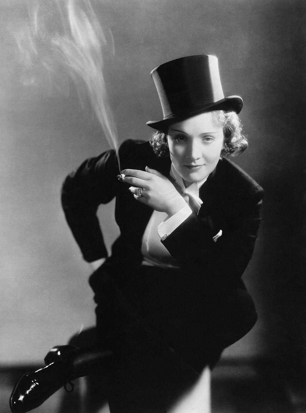 Marlene Dietrich Smokes A Cigarette, Wearing Top Hat And Tails In A Risque From The 1930S.