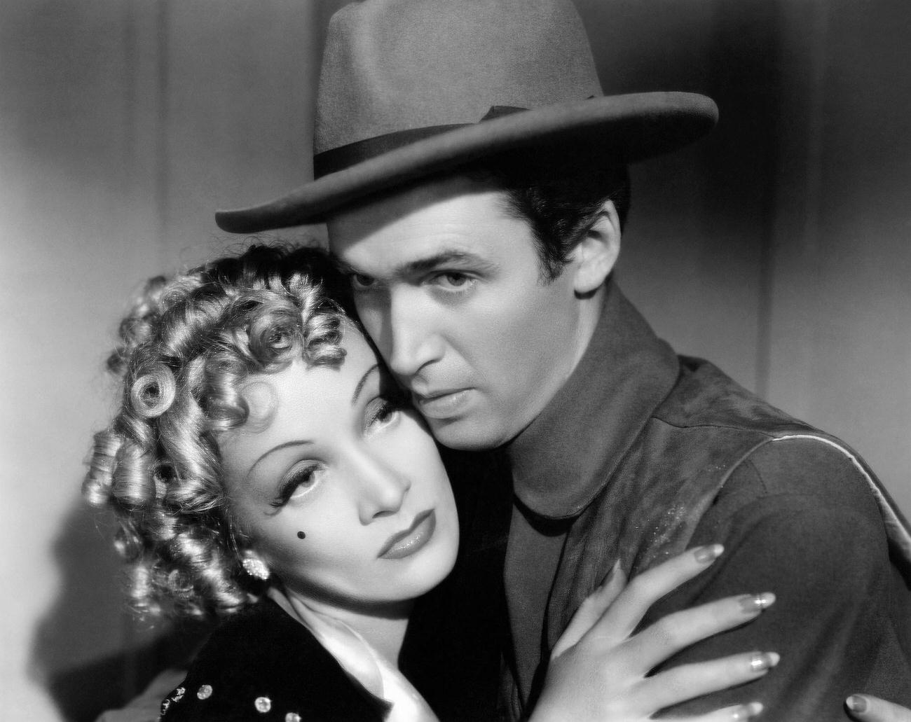 Marlene Dietrich And Tom Destry Jr. (James Stewart) Hold One Another Close.