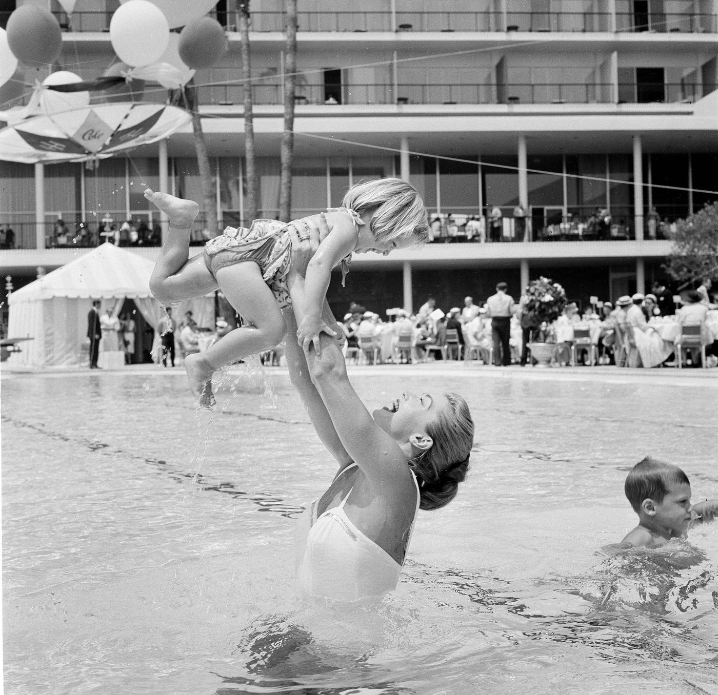 Esther Williams Lifts A Child In The Pool At Swim School Opening In Los Angeles On August 12, 1955