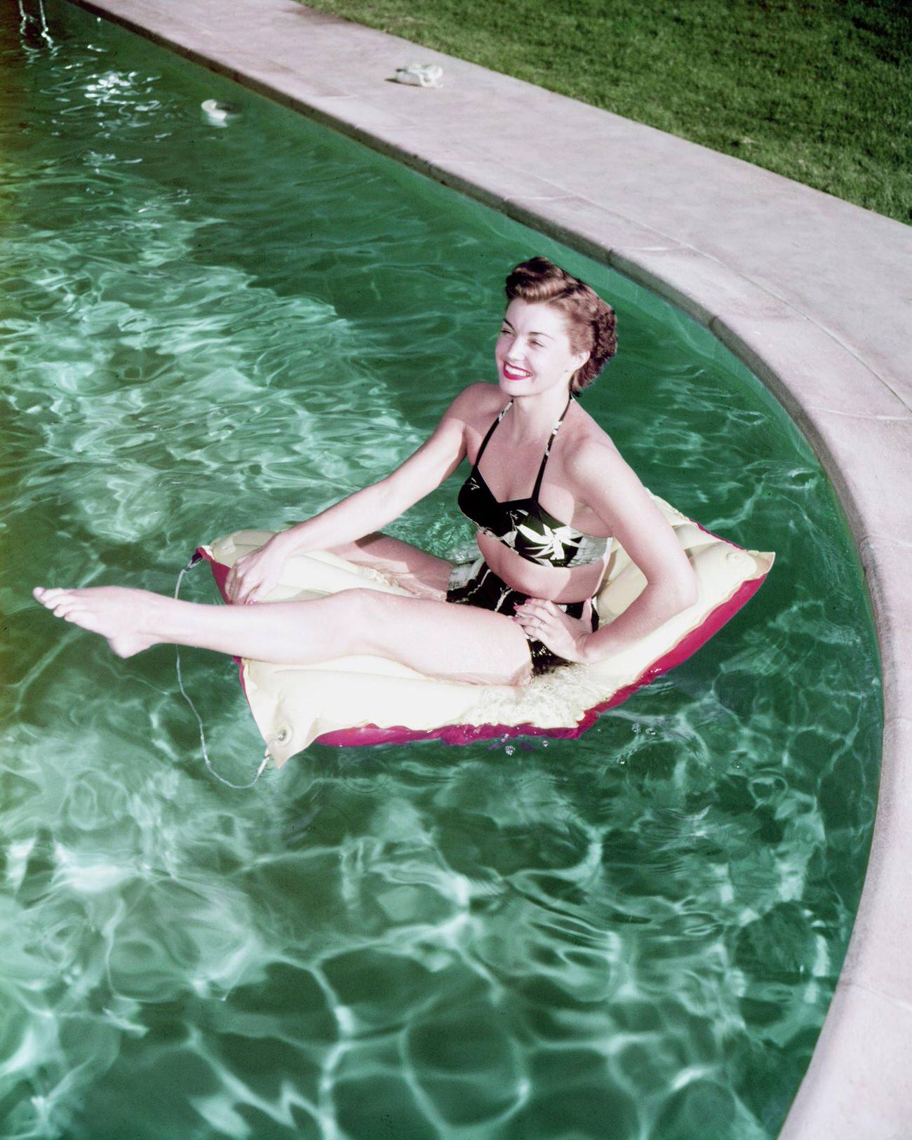 Esther Williams Sits On A Inflatable Float Mat In A Swimming Pool, 1955.