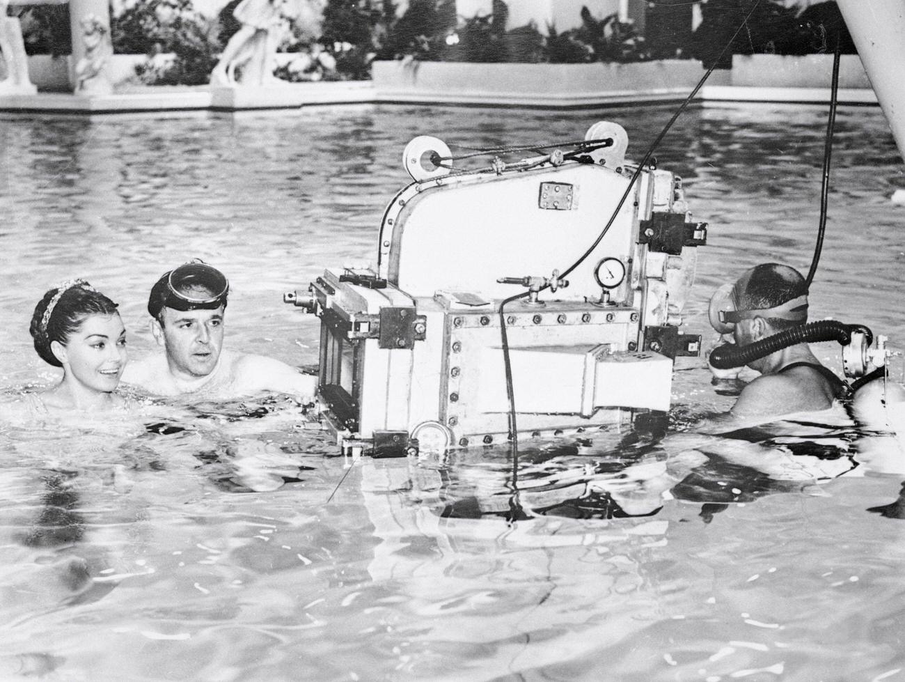 Esther Williams Listens To Explanations From Director George Sidney About The Underwater Camera That Will Photograph The Actress In Mgm'S Jupiter'S Darling, A Cinema Scope Musical Now In The Works.