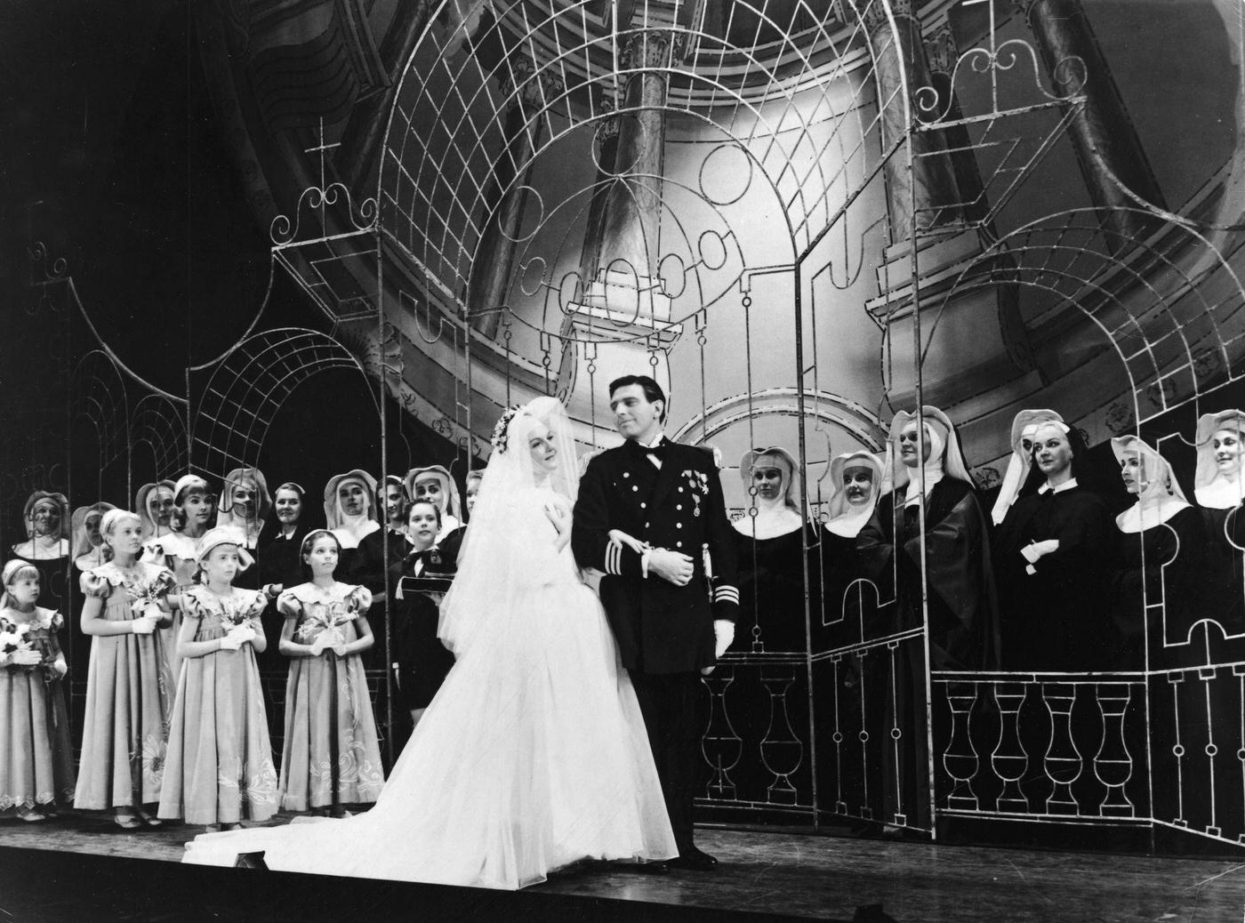 Mary Martin And Theodore Bikel Stand At A Stage Altar In Wedding Attire As A Group Of Nuns And Children Look On In The Wedding Scene From The Broadway Play, 'The Sound Of Music,' 1959