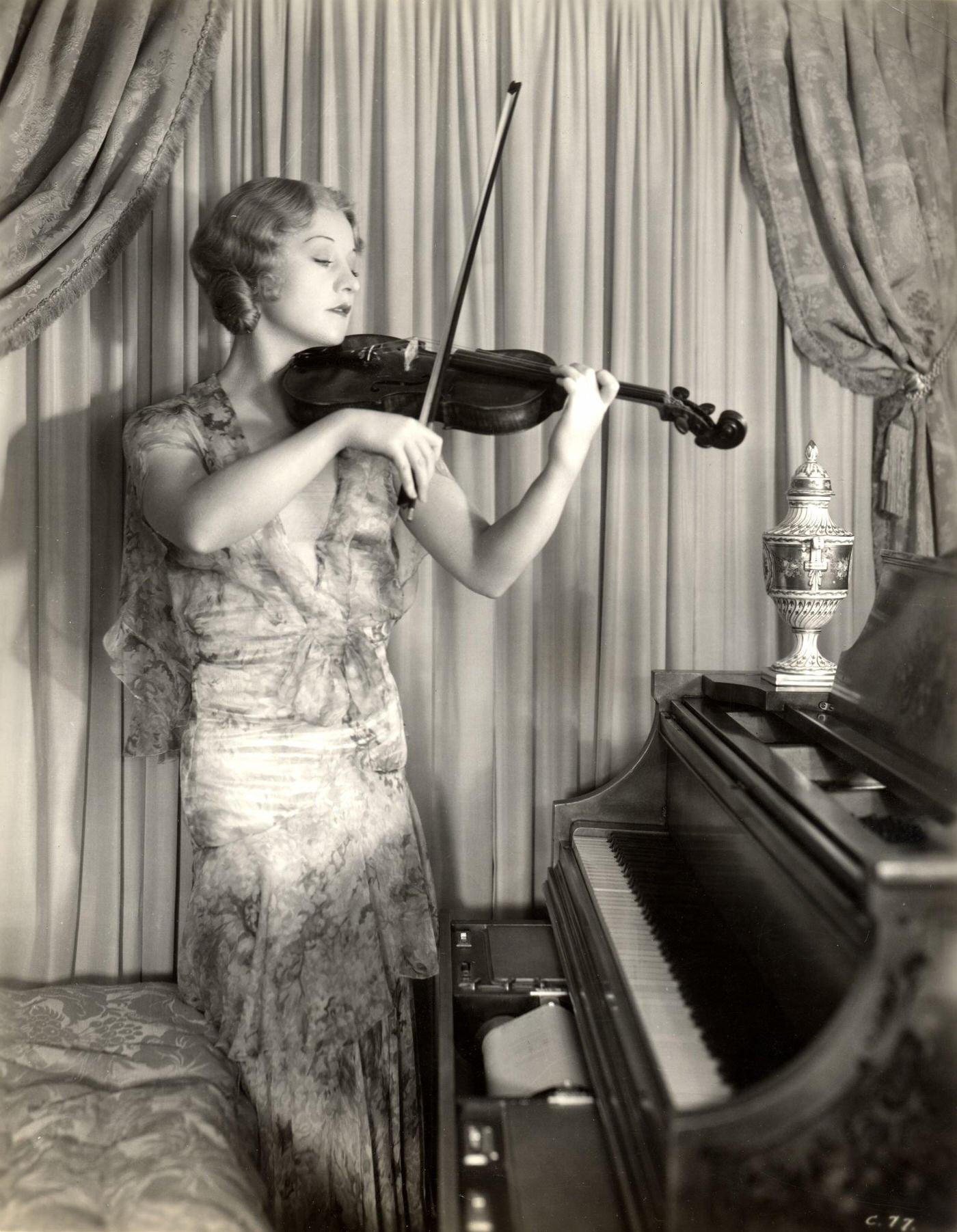 Betty Compson Plays Violin As She Stands Beside A Piano, 1930