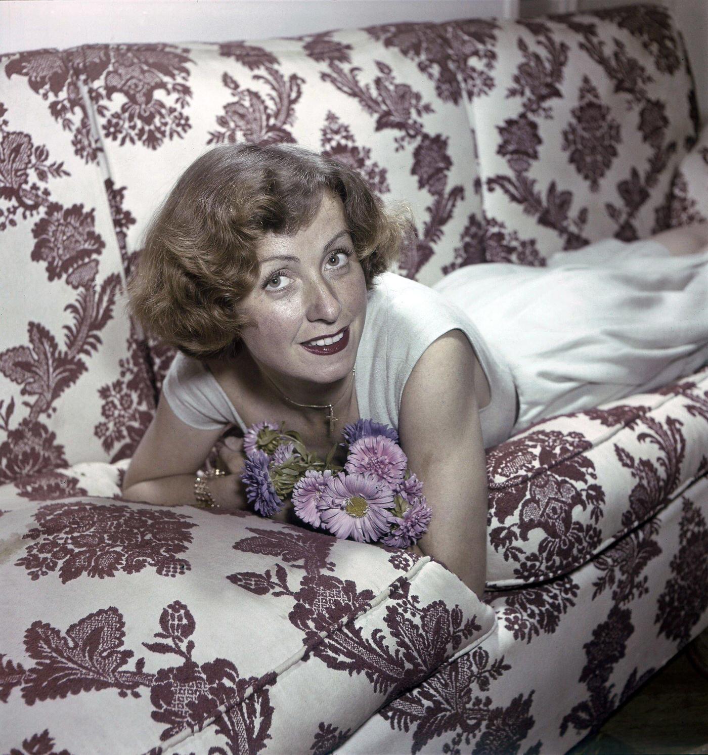 Danielle Darrieux Smiling, Lying On Her Couch At Home In Her Villa Du Coeur Volant.