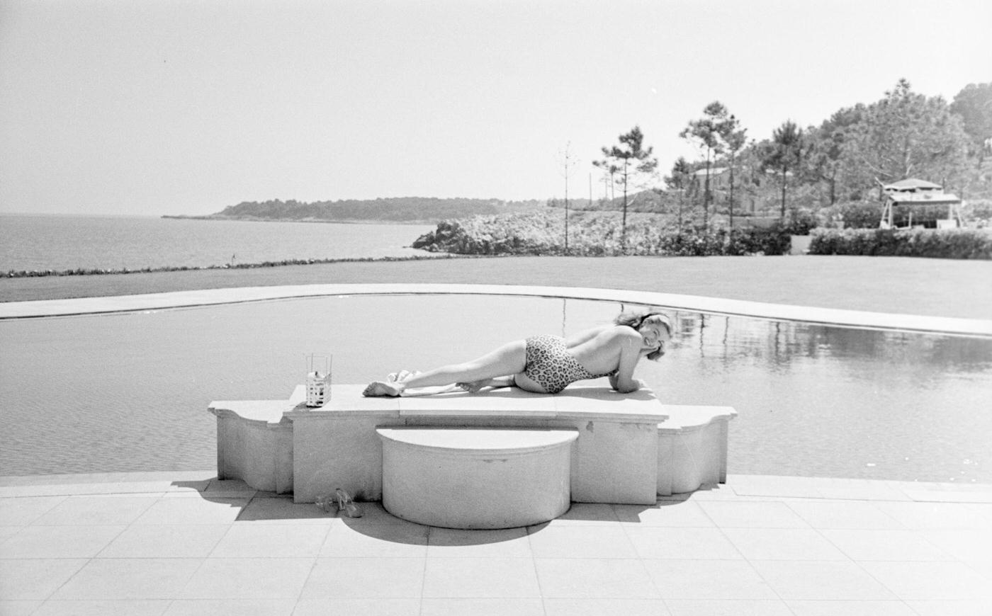 Esther Williamsin A Leopard Swimsuit, Lying By The Pool Of Her Friends. She Wears A One-Piece Swimsuit Because The American Censorship Forbids Her The Bikini.