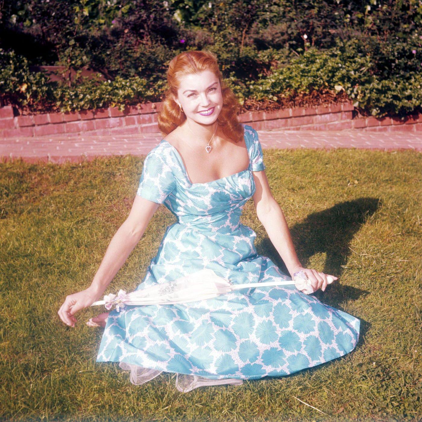 Esther Williams Wearing A Blue And White Floral Print Dress, Smiling While Sitting On A Patch Of Grass, 1950.