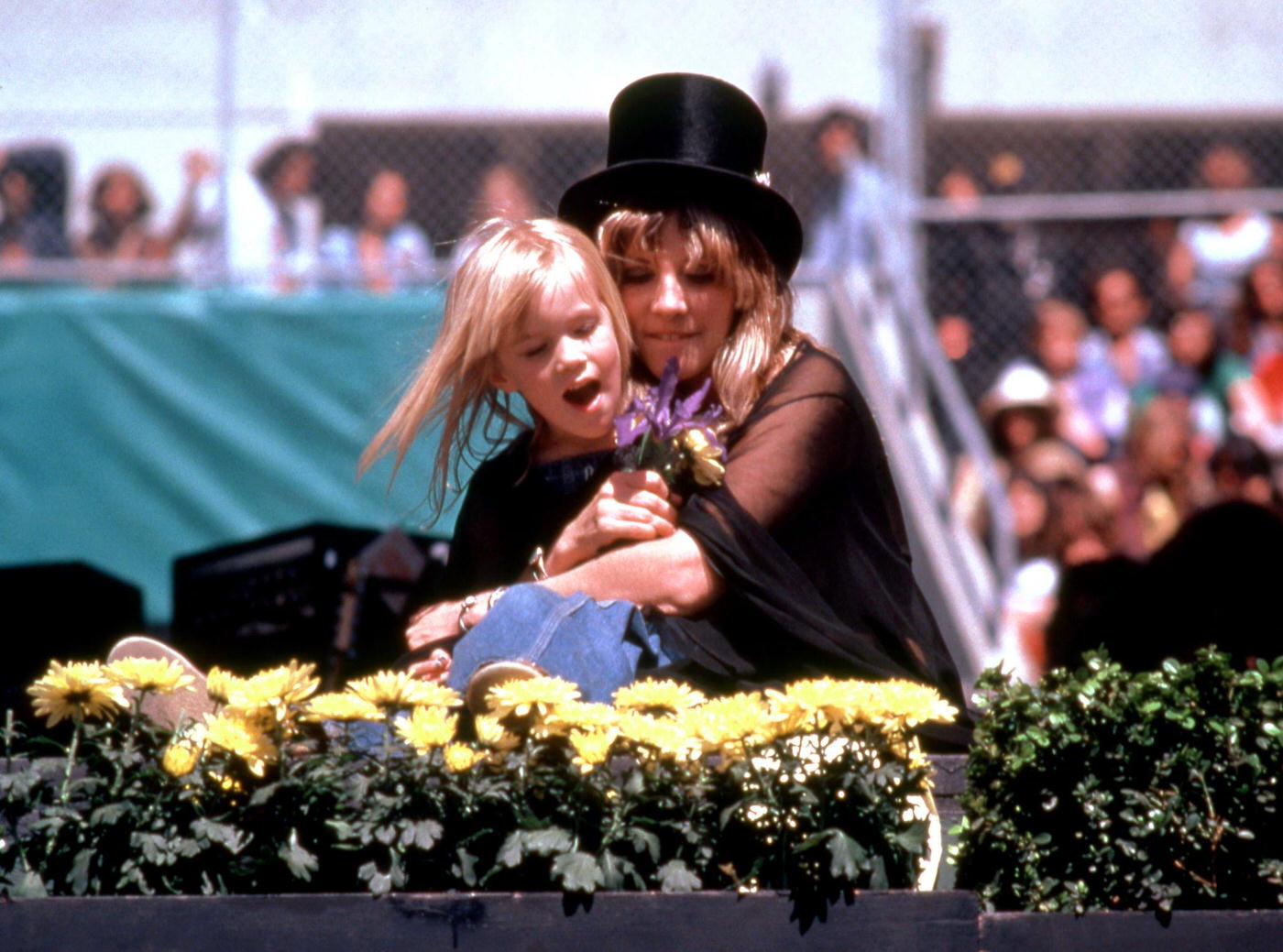 Stevie Nicks, Of The British-American Rock Band Fleetwood Mac, Holds A Child In The Crowd At Day On The Green #1, During The 1977 Rumours Tour