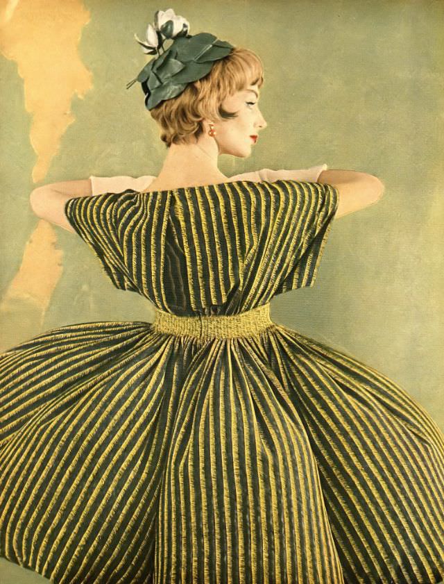 Ruth Neumann Derujinsky In Silk Crêpe Dinner Dress Of Yellow And Black Stripes On Green With Wide Kimono Sleeves By Galanos, Leafy Green Hat By Mr. Arnold, Harper'S Bazaar, April 1959