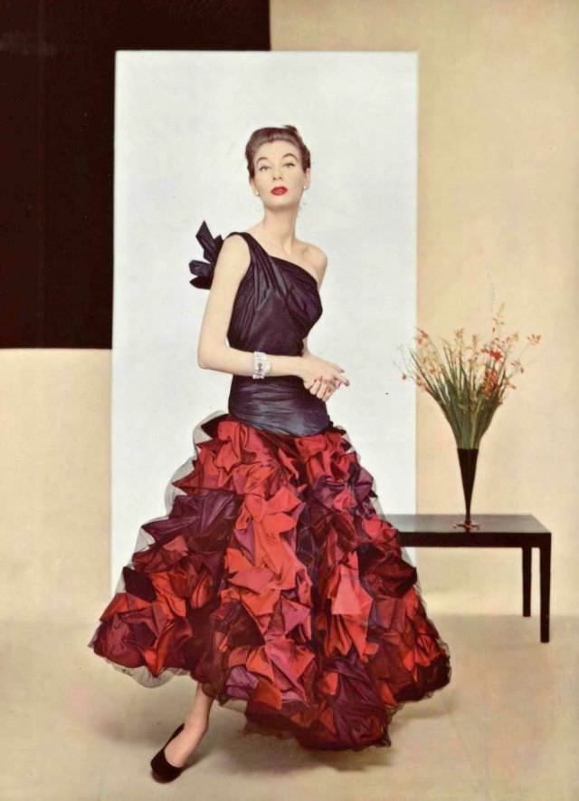 Model In Evening Gown Of Extraordinary Work In Taffeta, The Elongated Bodice Has One Shoulder Knotted In Back, Skirt Is Made Of Shells In Several Tones Covered With Fine Net Of Black Tulle By Grès, 1952