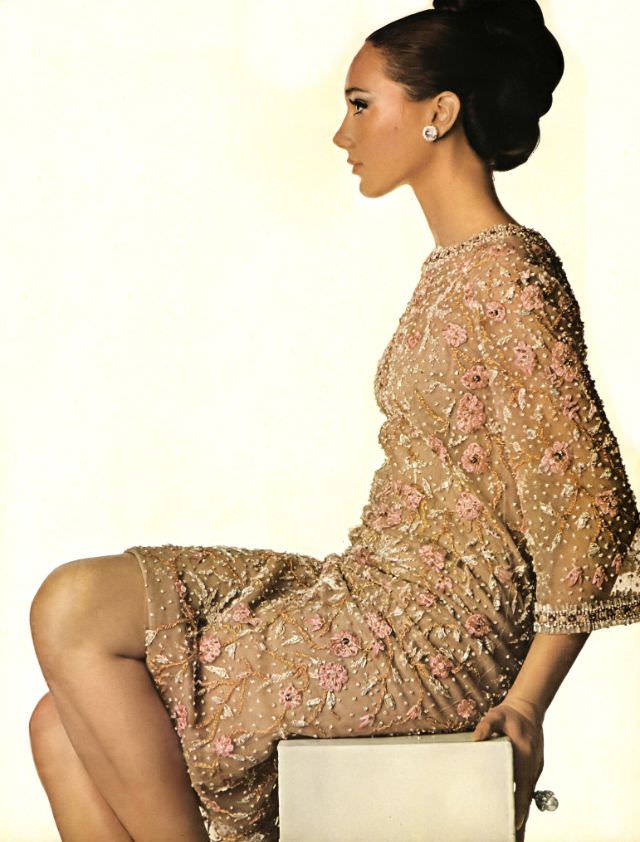 Marisa Berenson In Dress Of Pale Flowers Embroidered In Beads On A Nude-Colored Net Over Crêpe With Bands Of Silver And Gold At The Neck And Sleeves By Mollie Parnis, 1965