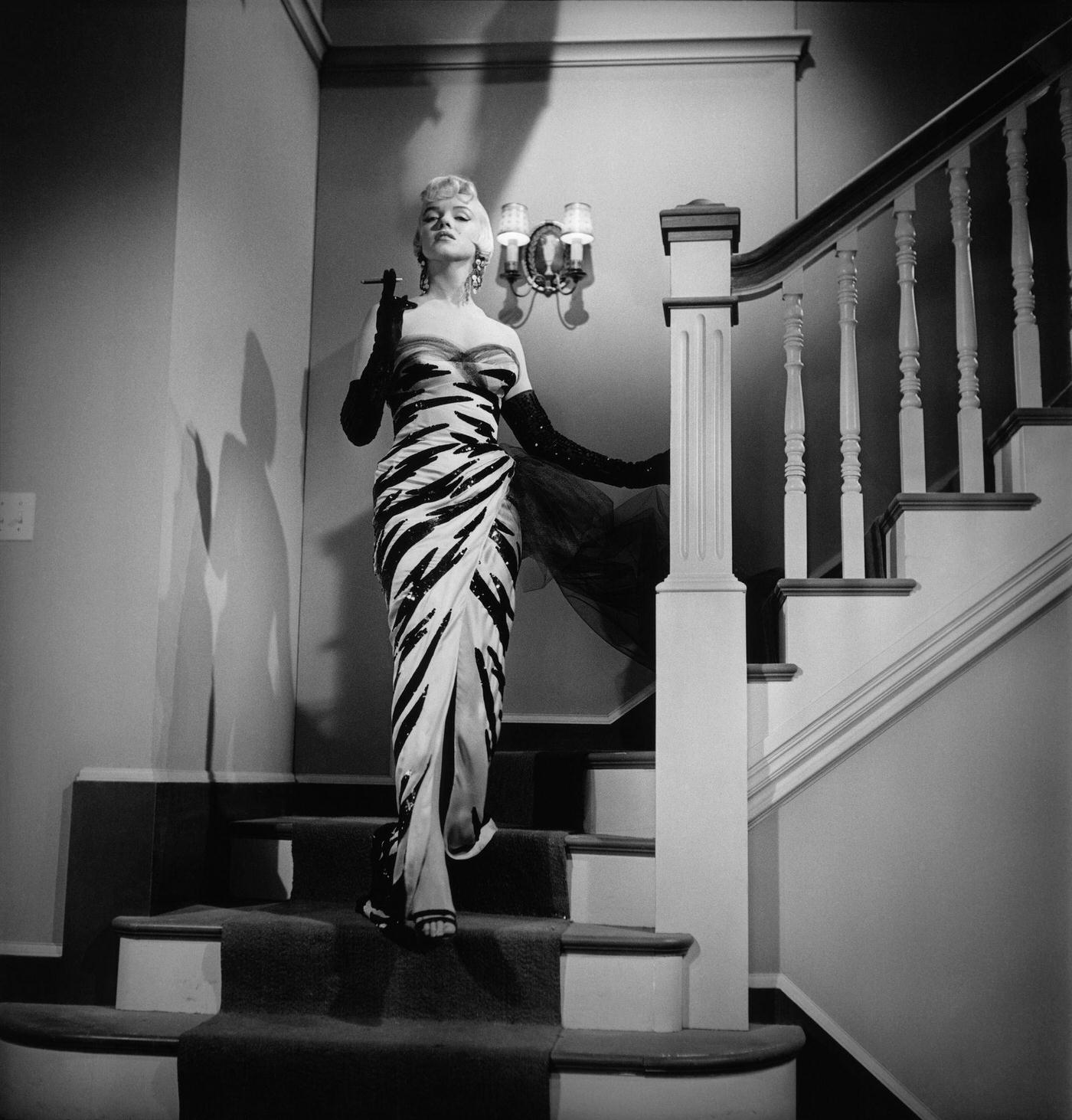 Marilyn Monroe ascends a staircase wearing a polka-dot dress in