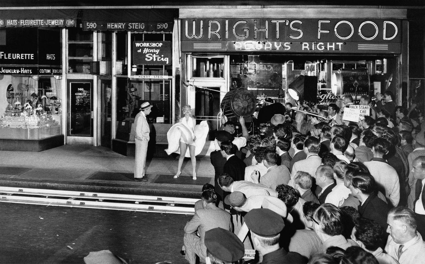 Marilyn Monroe Stands Over A Subway Grate With Her White Dress Blowing With Co-Star Tom Ewell And A Crowd Of Onlookers At The Corner Of 51St Street And Lexington Avenue During The Filming Of &Amp;Quot;The Seven Year Itch&Amp;Quot; In September, 1954