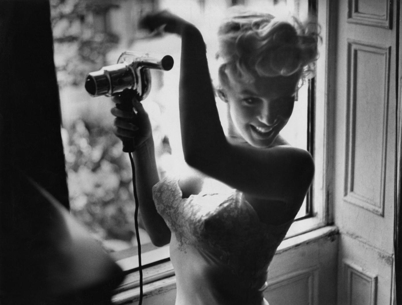 Marilyn Monroe Blow-Dries Her Hair In Front Of An Open Window In 1954 During The Filming Of &Amp;Quot;The Seven Year Itch&Amp;Quot; In New York