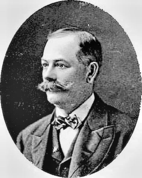 Man’s Hair Is Parted On The Side, Cut Above The Ears, And Wears A Full Mustache.