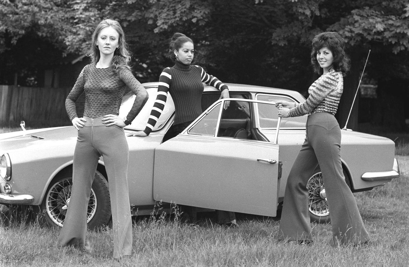 Three Young Women In Bell Bottoms Posing Against A Car In London'S East End, 1970