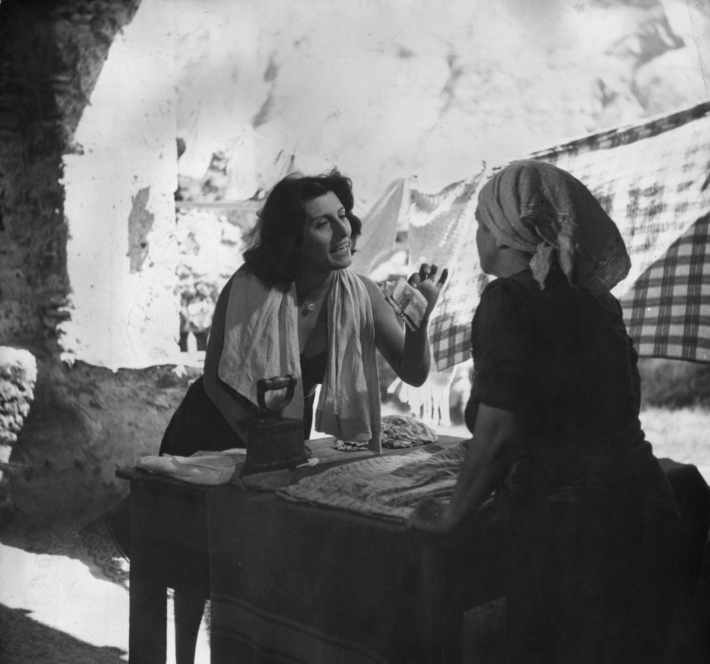 Anna Magnani Offers Money To A Woman In A Scene From The Italian Film Drama 'Vulcano', 1953.