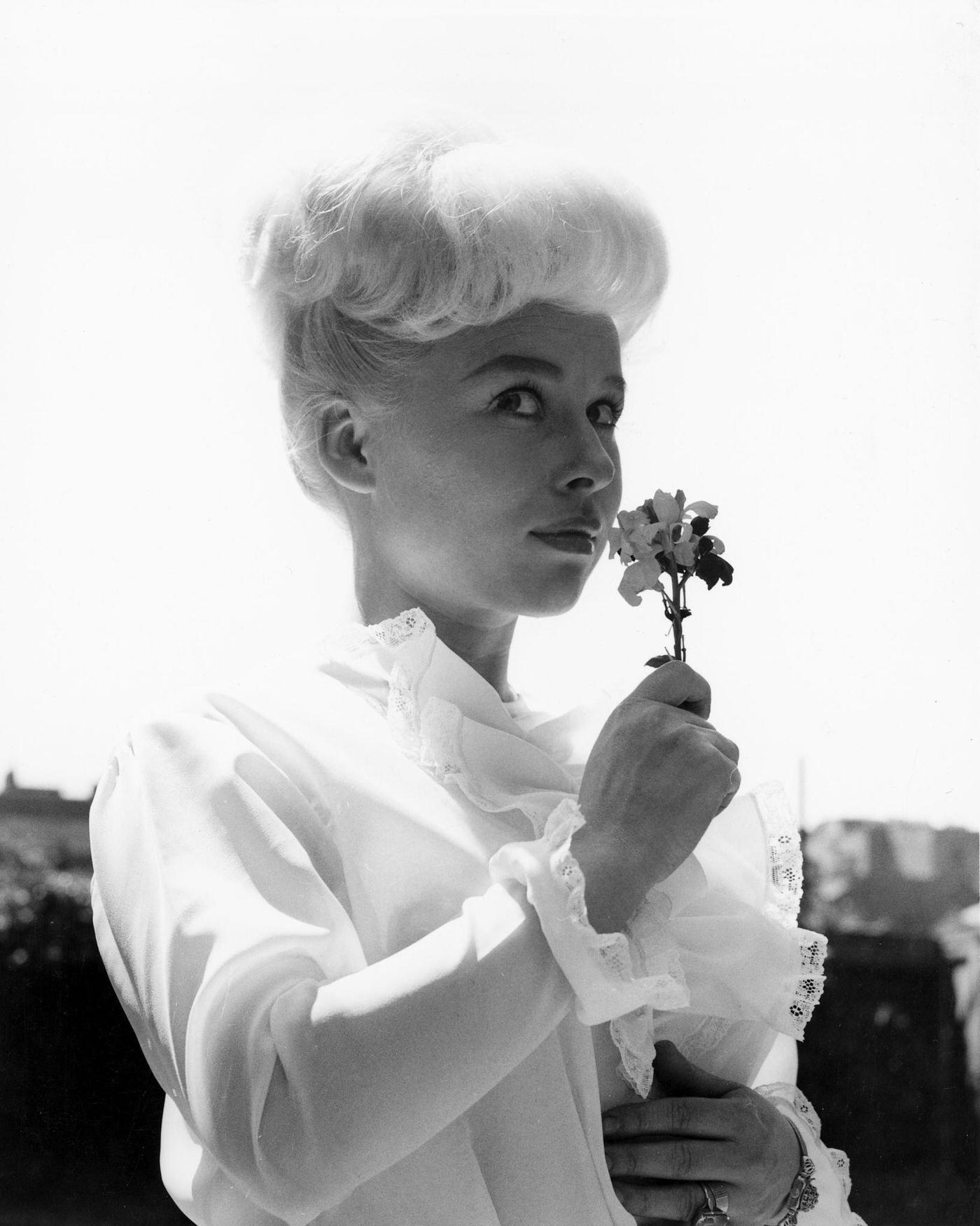 Barbara Windsor Wearing A White Blouse, Sniffing A Flower, Circa 1960.