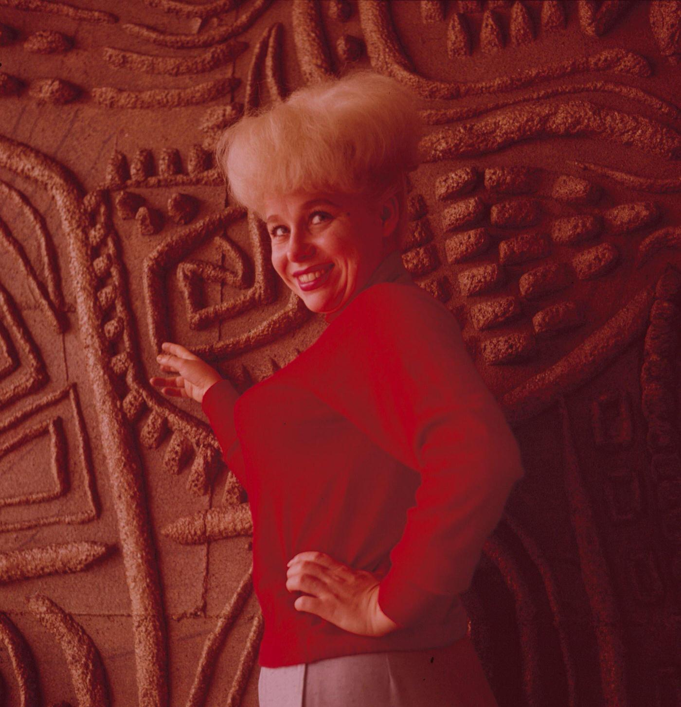Barbara Windsor In A Red Jumper Beside A Carved Wood Panel In London, 1964.