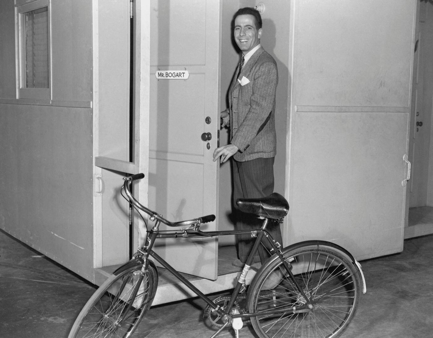 Humphrey Bogart Going In To His Dressing Room With A Bicycle Parked Out Front, 1940