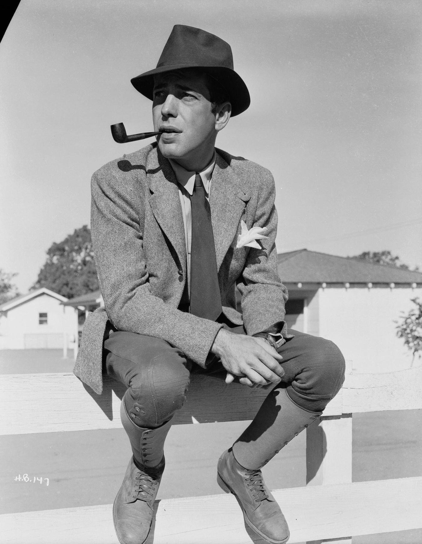 Humphrey Bogart Sitting On A Fence Smoking A Pipe, 1940
