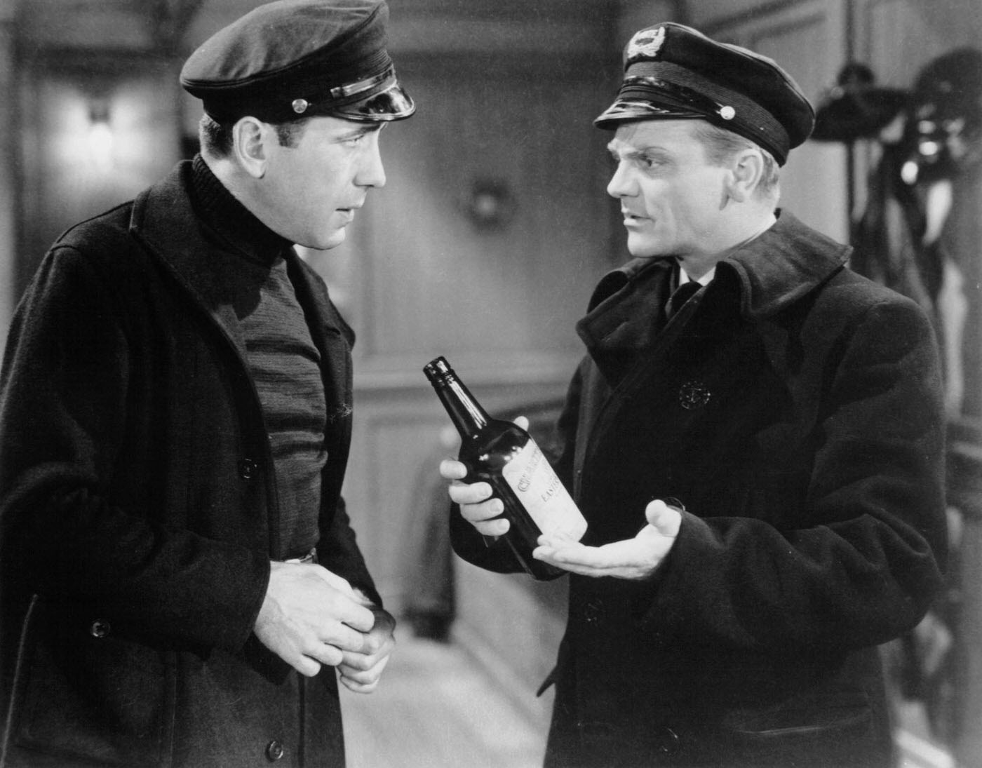 Humphrey Bogart Talks To James Cagney Who'S Holding A Bottle In A Scene From The Film 'The Roaring Twenties', 1939.