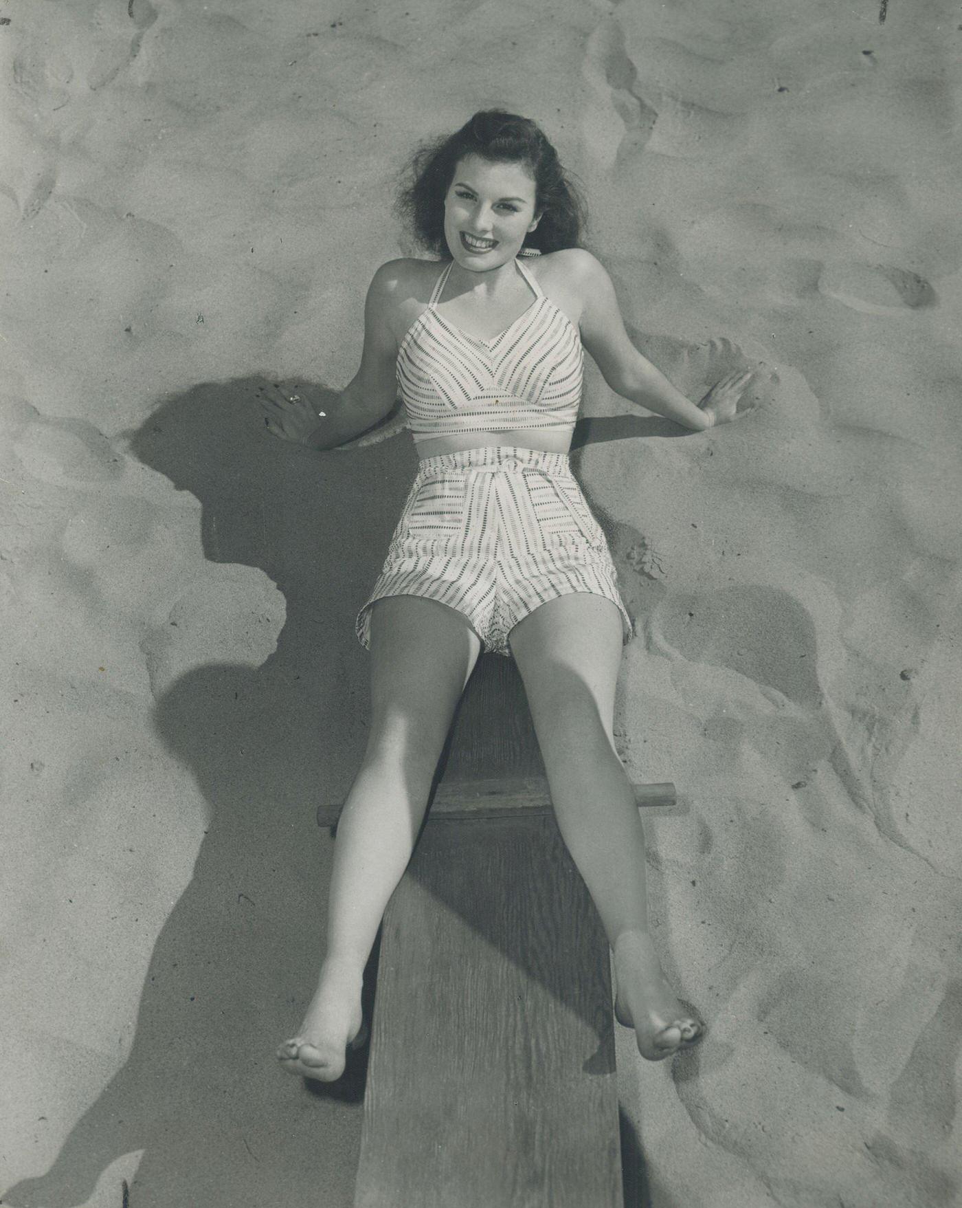 Screen Star Sheila Ryan Acquires A Suntan For Her Next Hollywood Movie Role On A Beach Teeter-Totter In Canada, July 29.