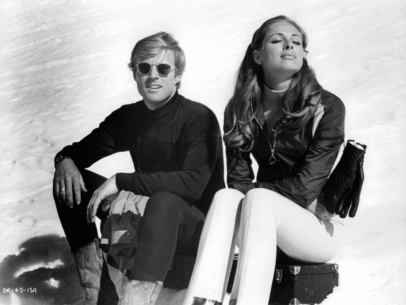 Robert Redford And Camilla Sparv Sitting On A Snow-Covered Slope In A Scene From 'Downhill Racer', 1969.