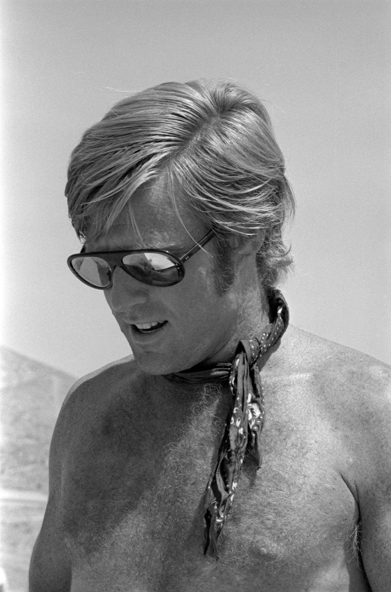 Close-Up Of Robert Redford Posing Shirtless With Sunglasses And A Bandana Around His Neck, 1969.