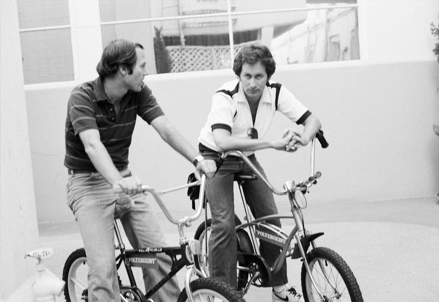 Frank Marshall (Film Producer) And Steven Spielberg Sitting On Bicycles While Talking In Los Angeles, California, 1981.