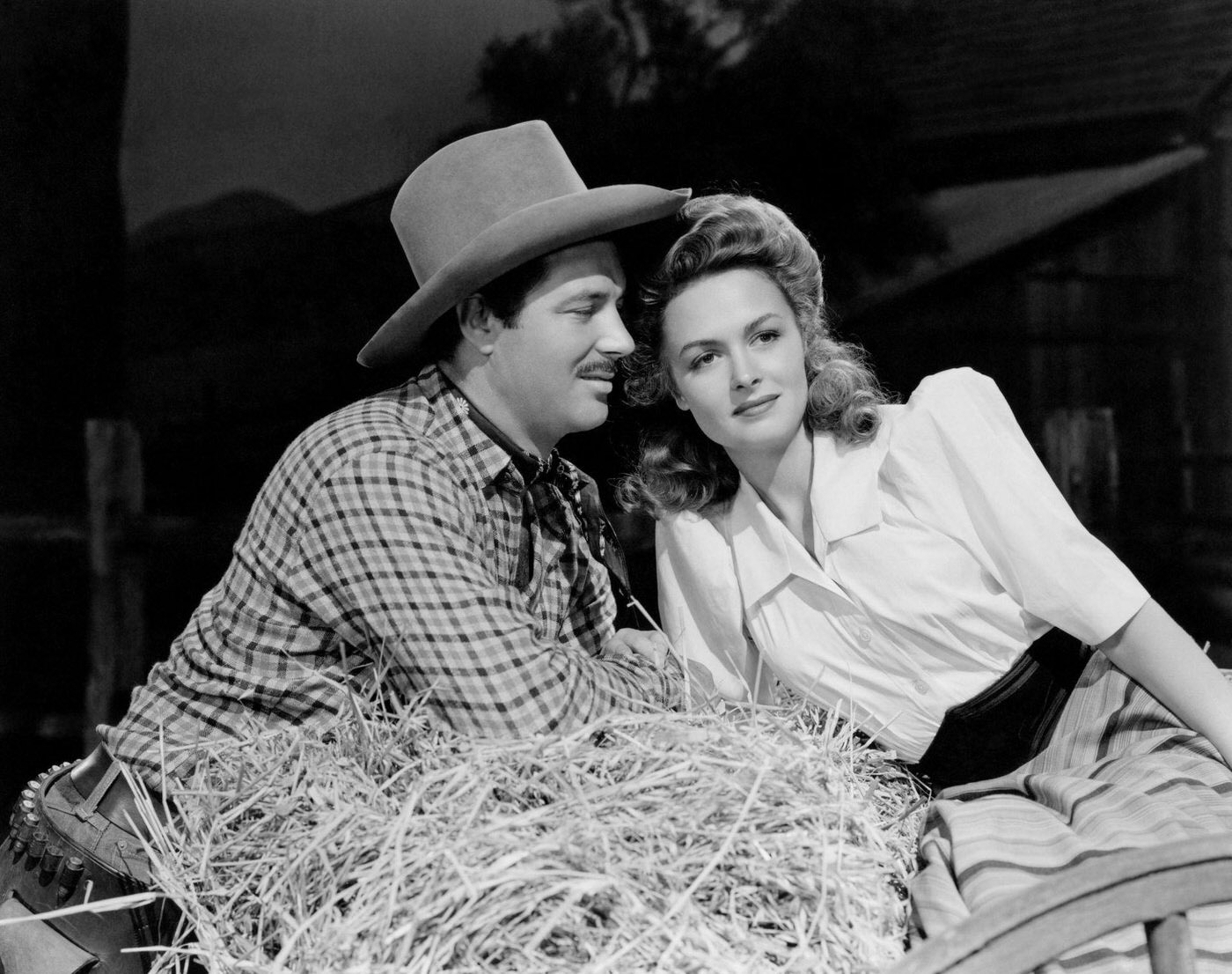 James Craig And Donna Reed Sitting On A Cart Full Of Straw In A Publicity Shot From The 1944 Movie &Amp;Quot;Gentle Annie.&Amp;Quot;