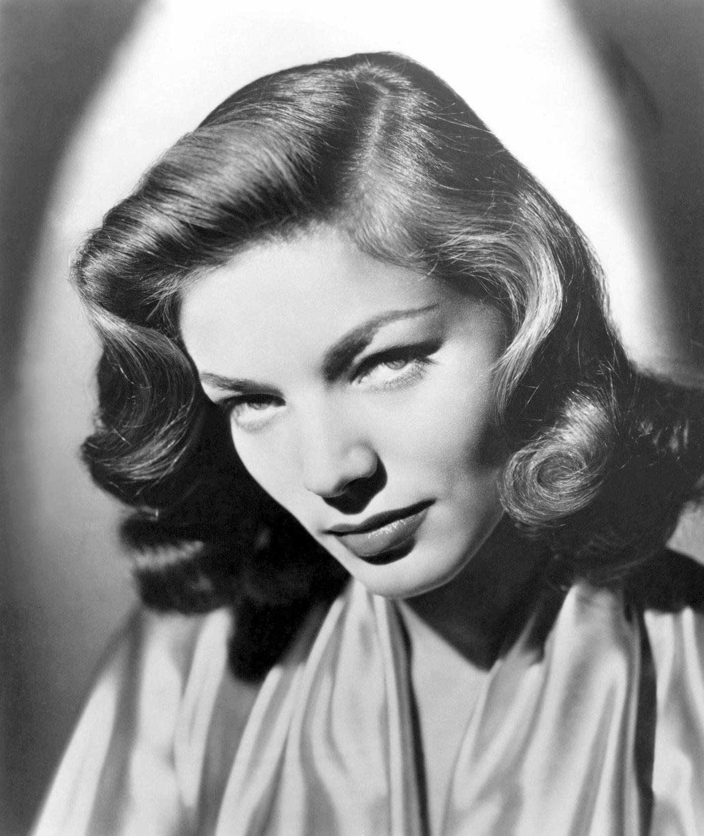 Lauren Bacall Pictured In A Glamorous Pose With A Fur Coat Draped Over Her Shoulders.