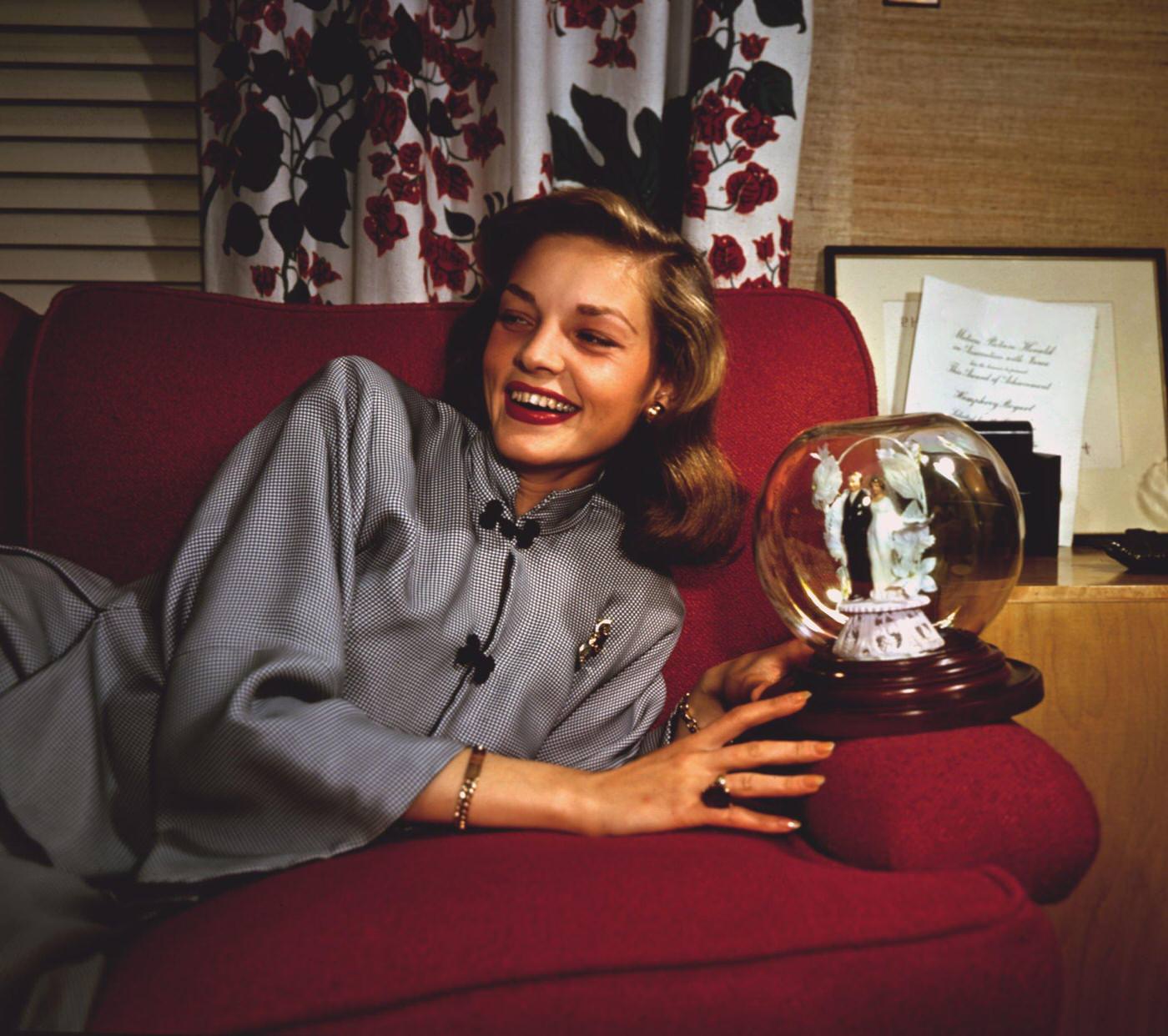 Lauren Bacall Relaxes On Sofa, Holding Globe Ornament From Her Wedding Cake, In The Usa In 1947.