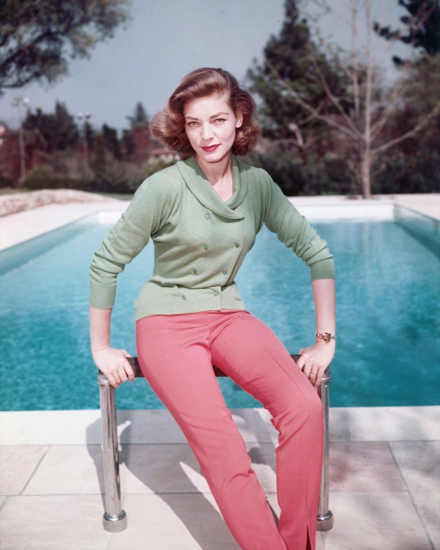 Lauren Bacall Poses In Green Double-Breasted Cardigan And Red Trousers Beside A Swimming Pool 1950.