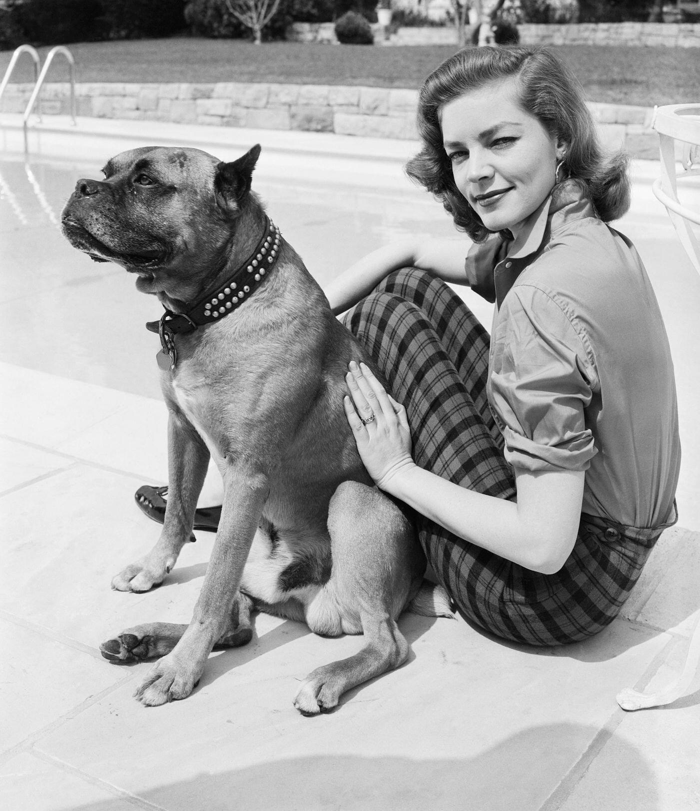Lauren Bacall Relaxes Beside A Pool With Her Pet Boxer In Hollywood, California In 1955.
