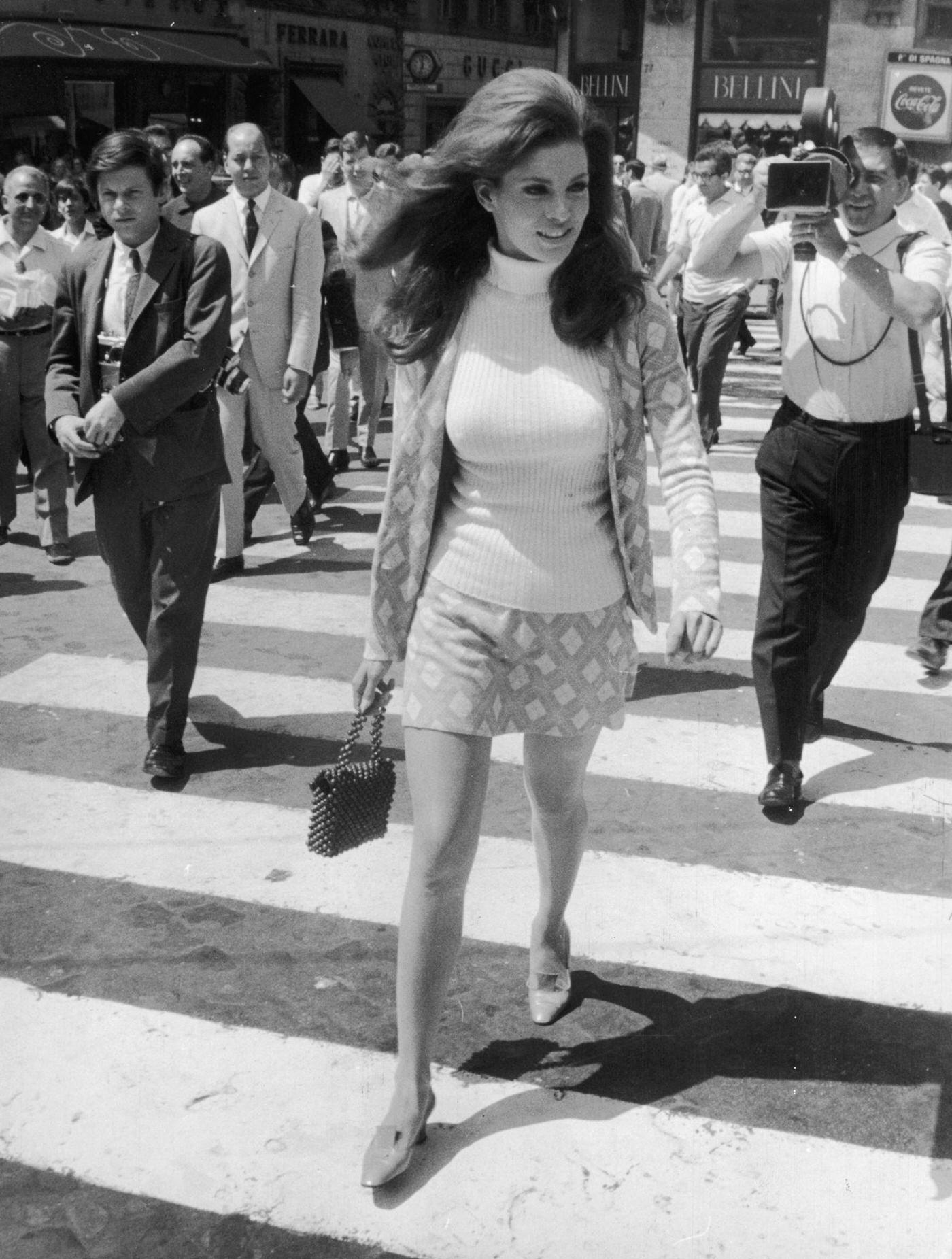 Raquel Welch Crossing A Zebra Crossing In Rome, Wearing A Mini-Skirted Suit And A Skinny-Rib Polo Sweater, Followed By Photographers.