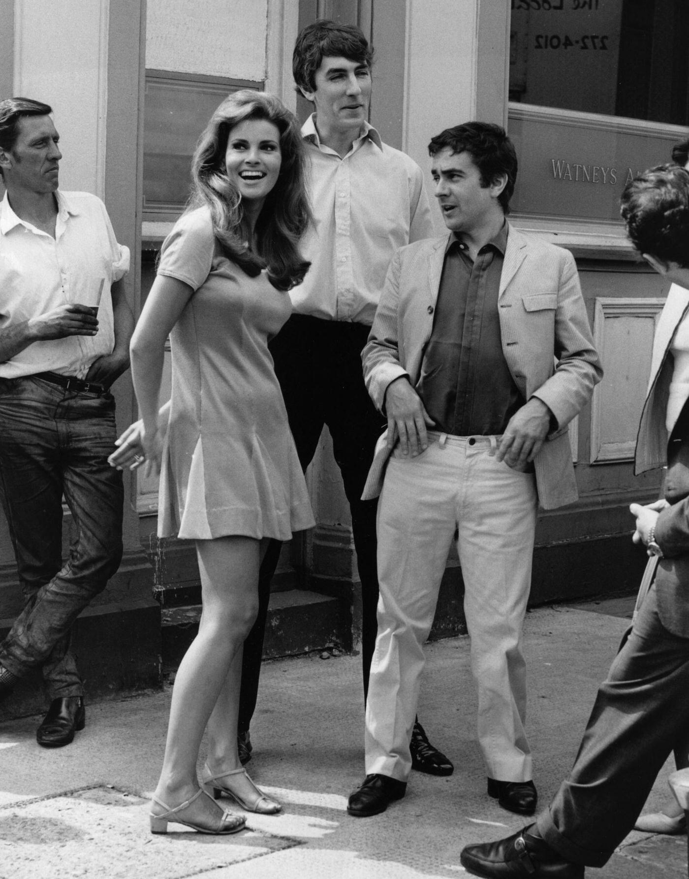 Raquel Welch With Peter Cook And Dudley Moore During The Filming Of 'Bedazzled' Outside The Harwood Arms In London, 1967.