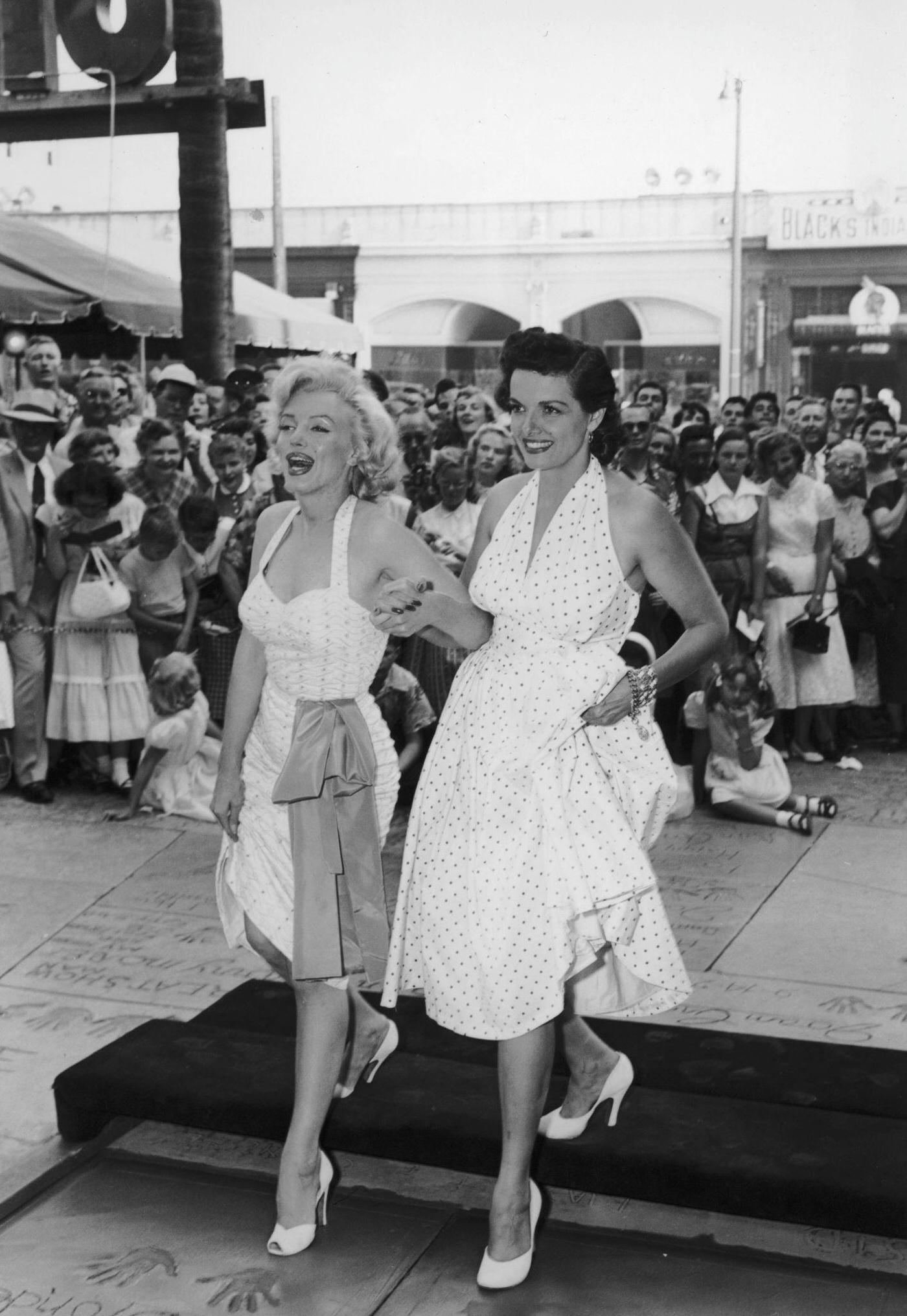 American Actresses Marilyn Monroe And Jane Russell Press Heel Prints In Wet Cement At Grauman'S Chinese Theater, 1953.