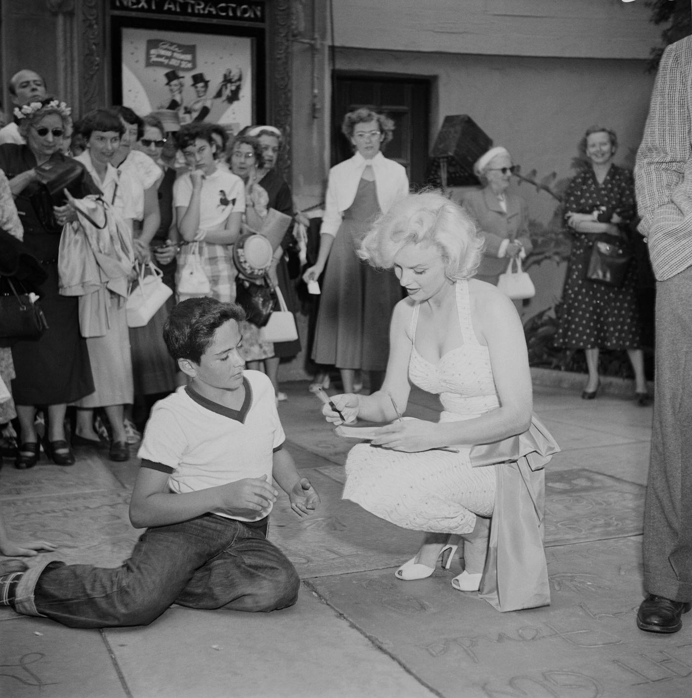 Monroe Signs Autograph For A Fan Outside Grauman'S Chinese Theatre In Hollywood, California, At A Joint Handprint Ceremony With Jane Russell For 'Gentlemen Prefer Blondes', 1953.