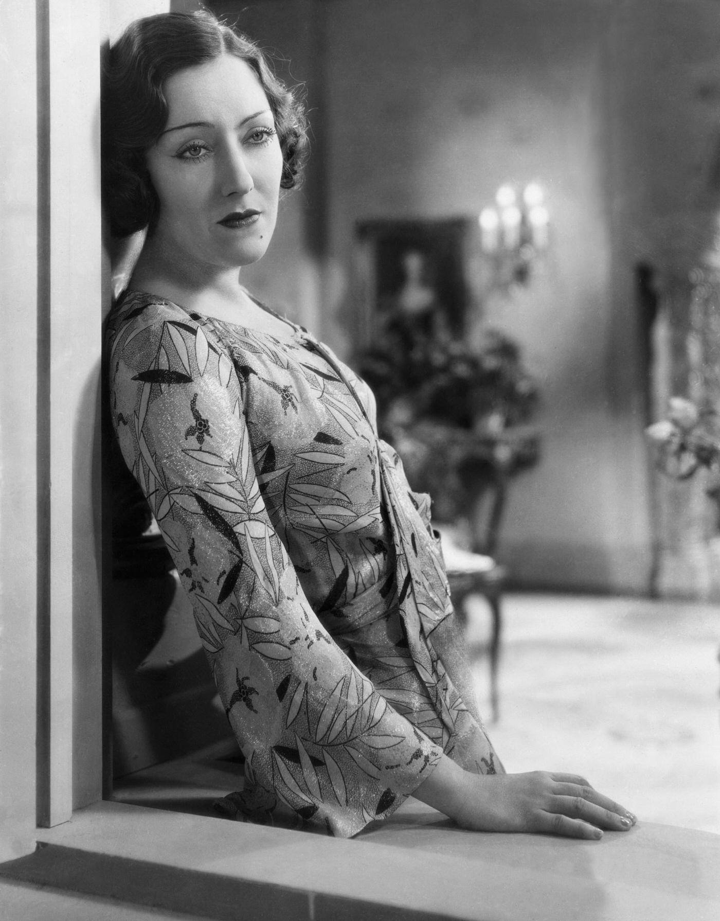 Actress Gloria Swanson Looking Out A Window. Undated Photograph.