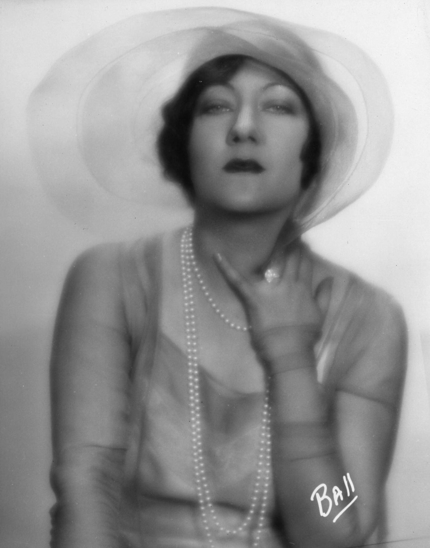 Gloria Swanson Fingers A Triple-Stranded Pearl Necklace, Circa 1930.