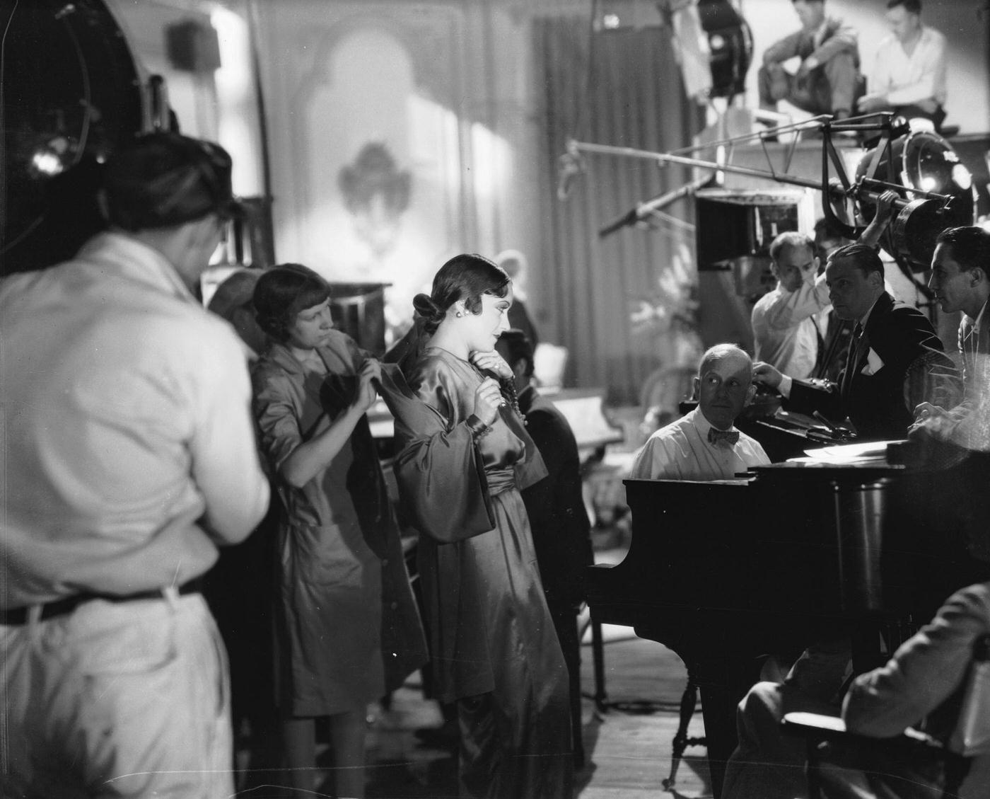 Gloria Swanson Has Her Costume Adjusted By A Studio Dresser, Circa 1930.
