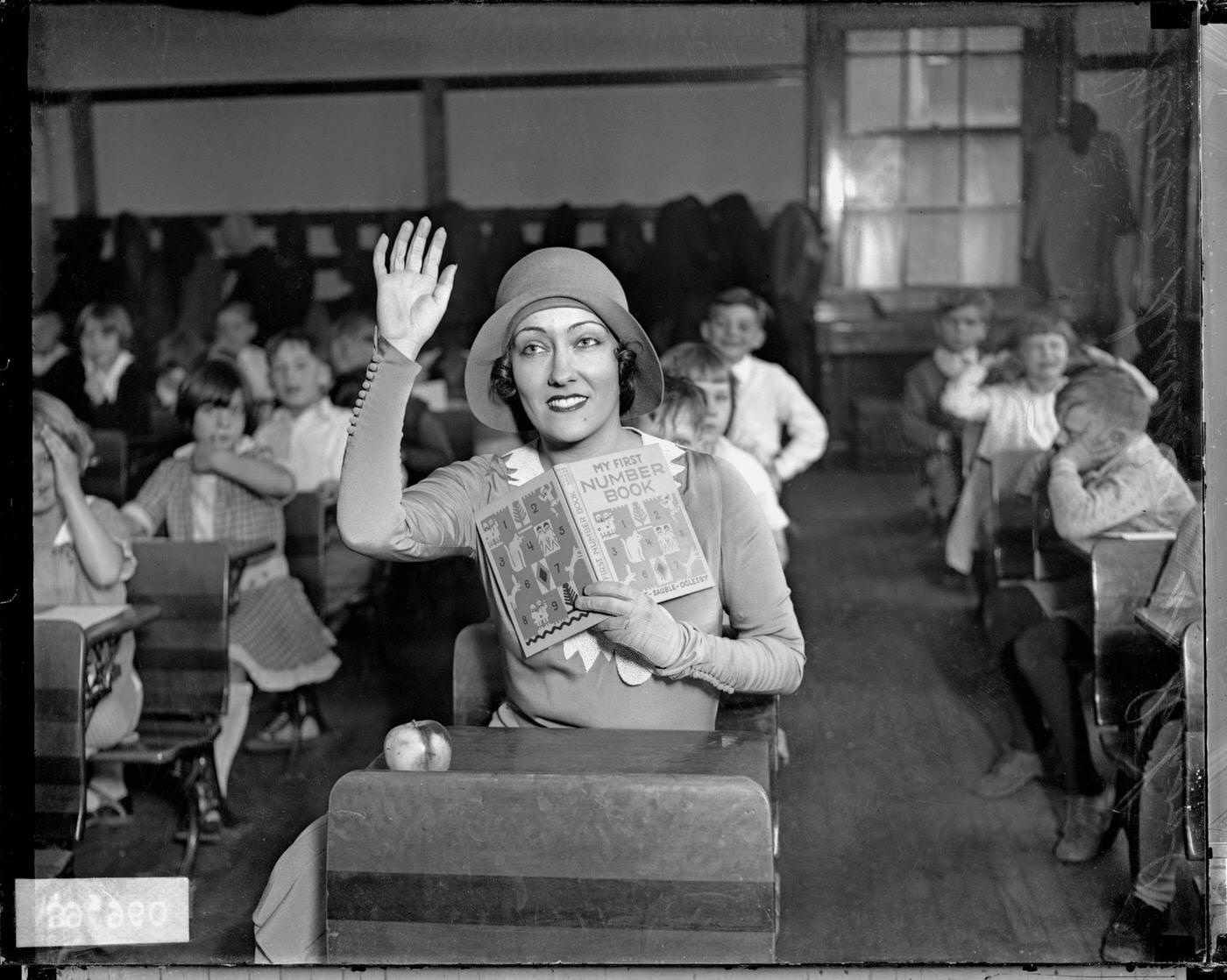 Gloria Swanson Sitting In A Classroom With Children, Chicago, Illinois, 1929.