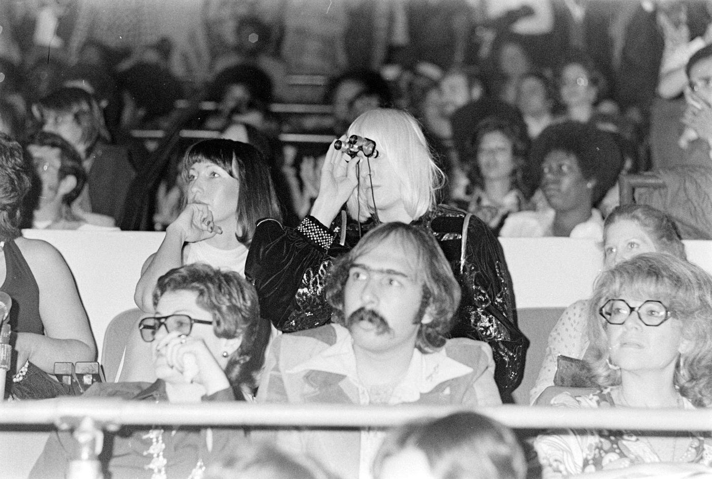 Edgar Winter (C) Using Binoculars To Watch Sly Stone'S Concert And Onstage Wedding To Kathy Silva At Madison Square Garden, Nyc, 1974.