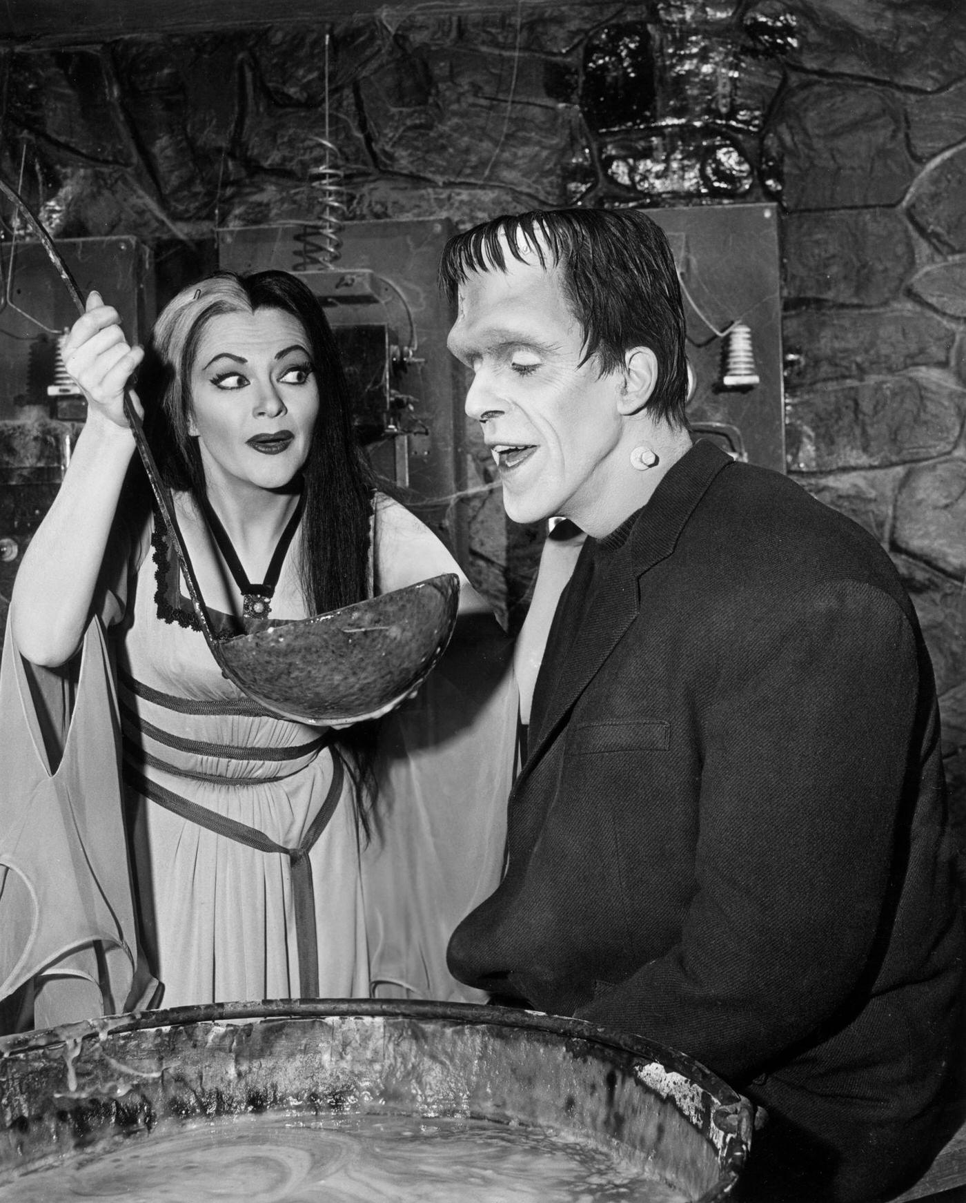 Yvonne De Carlo Holds A Giant Ladle For Fred Gwynne In A Scene From 'The Munsters,' 1964.