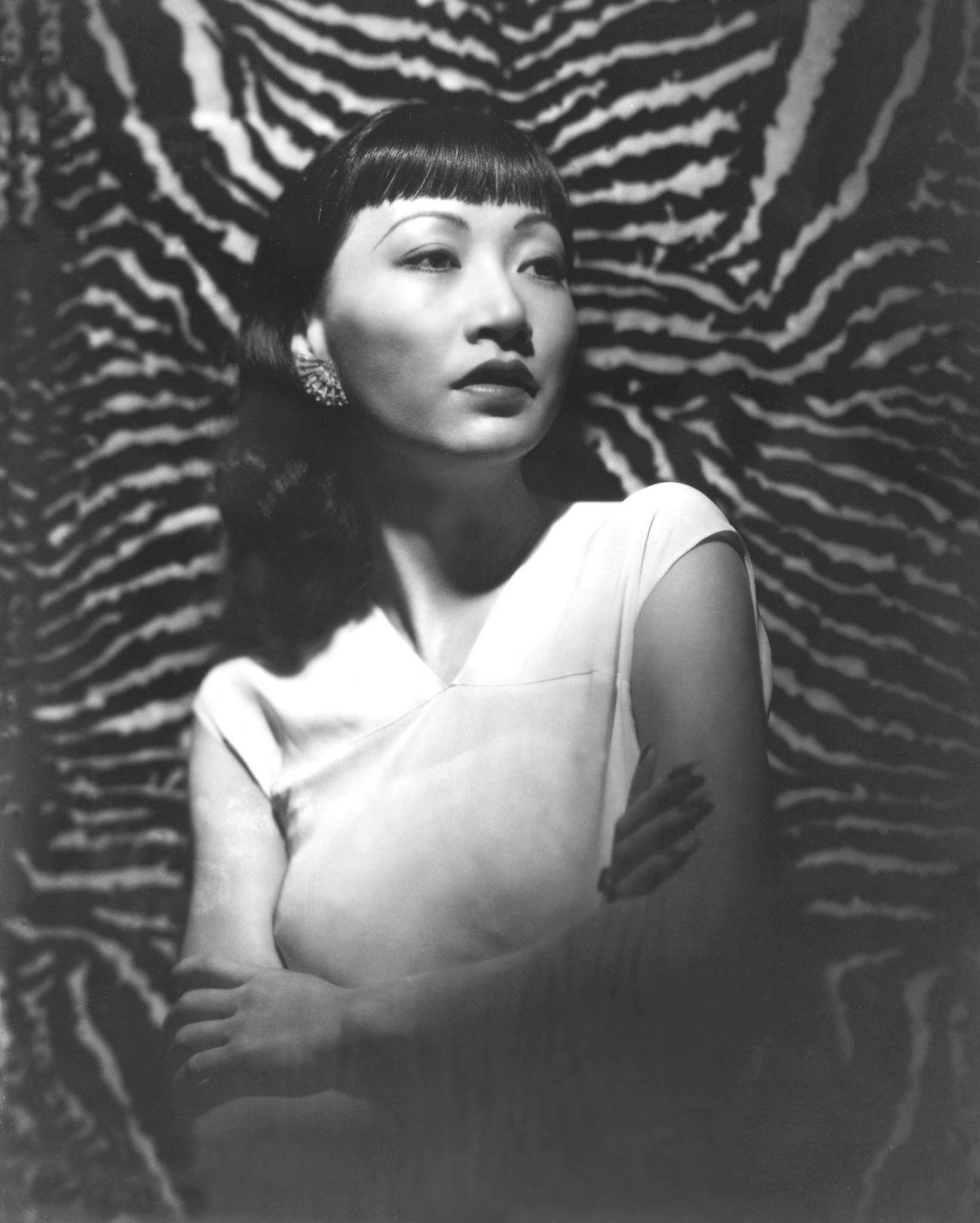 Anna May Wong In A Sleeveless White Top Against A Tiger Skin Background, Circa 1930.