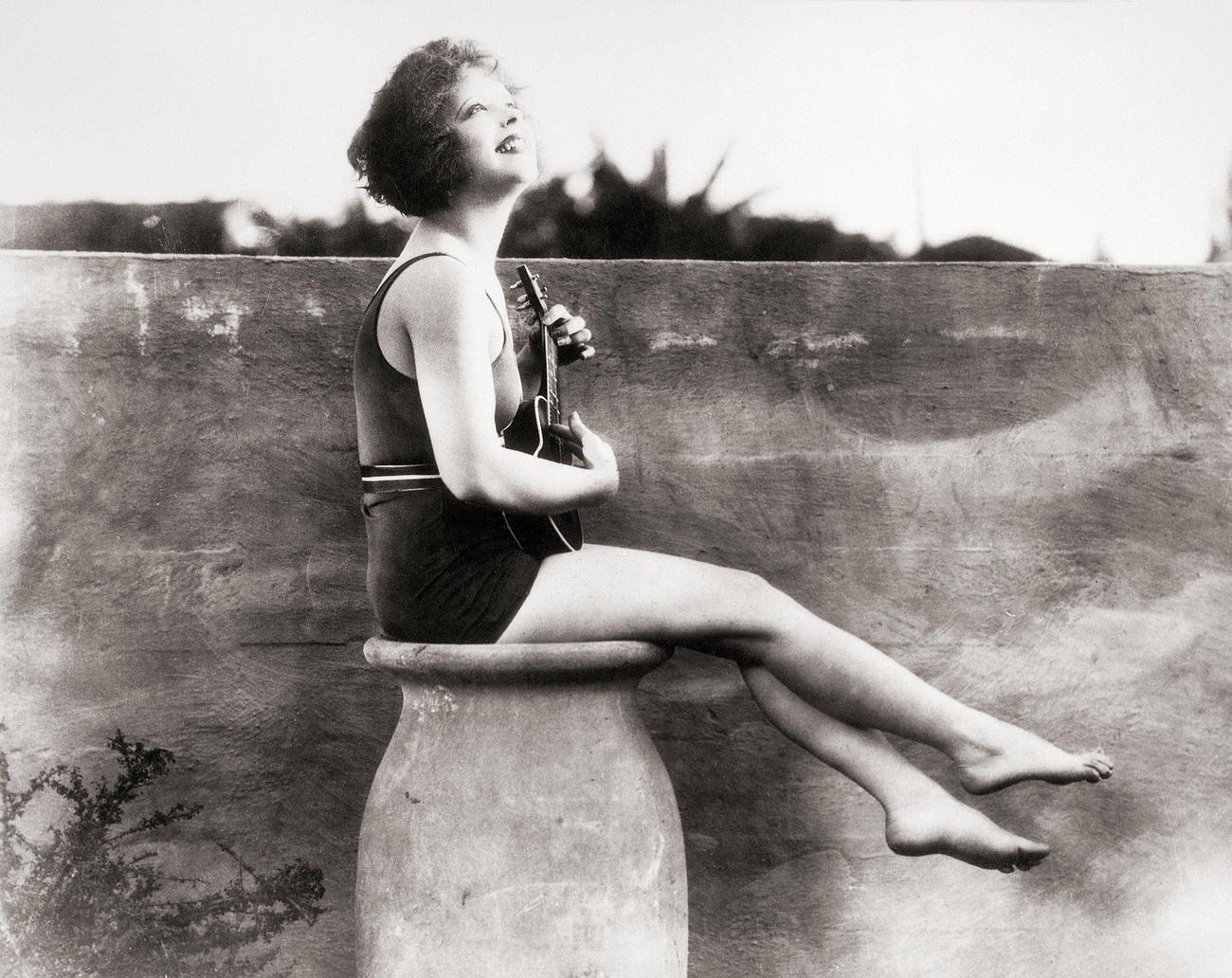 Clara Bow In A Bathing Suit Playing A Ukulele, 1927.
