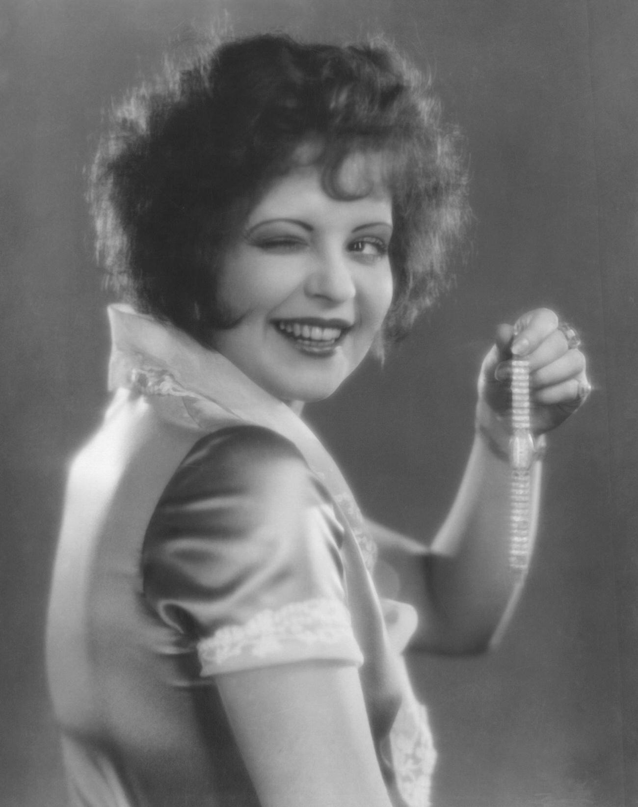 Clara Bow Holding A Gold Diamond-Studded Watch From 'Red Hair', 1927.